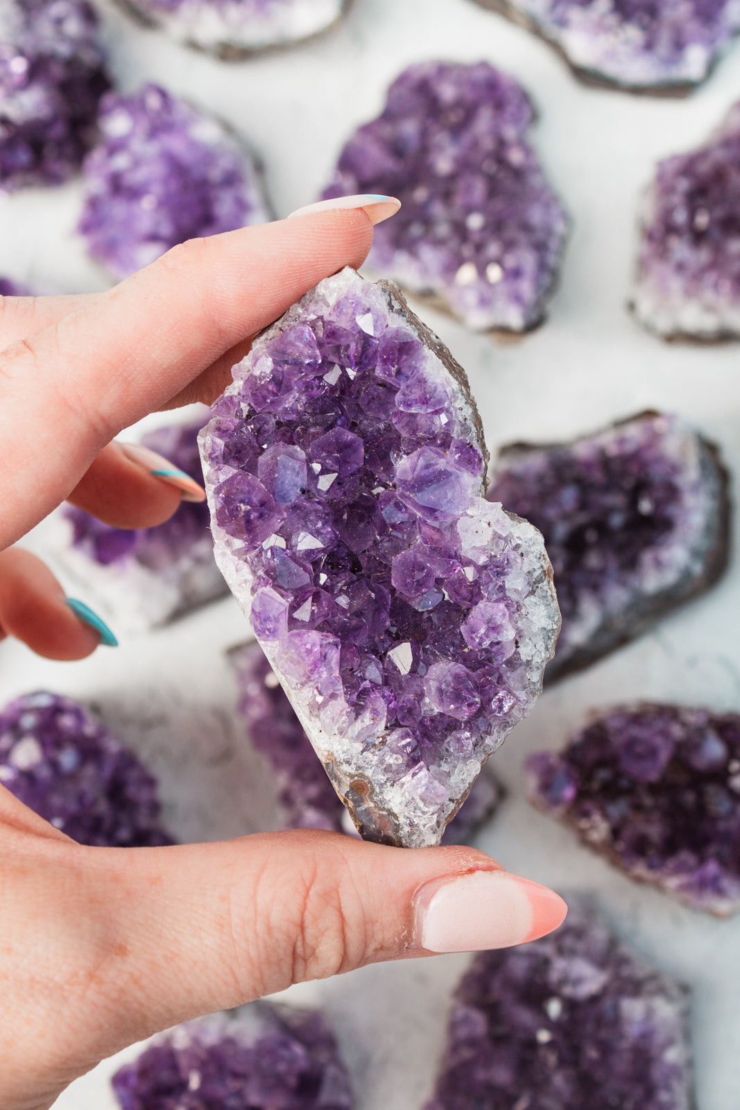 Hand holding amethyst cluster.