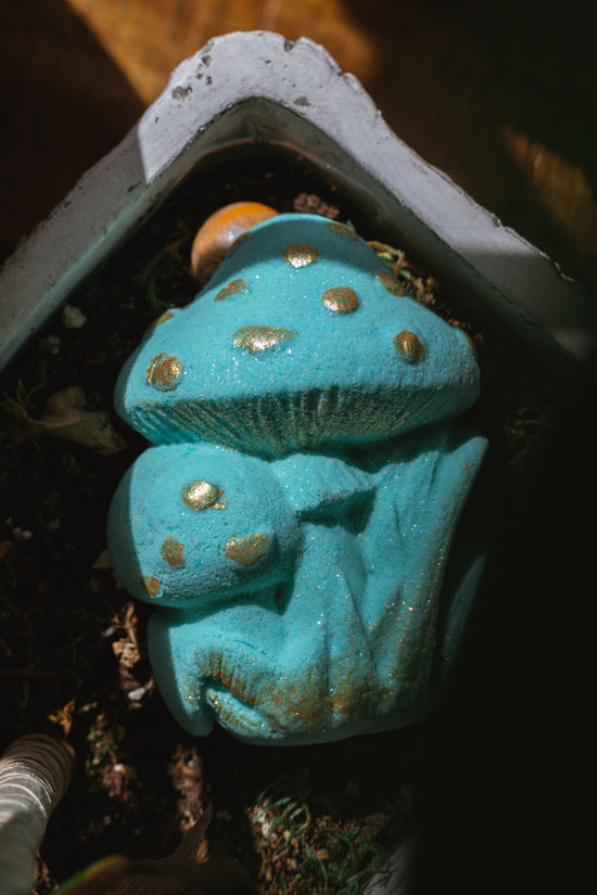 organic bath bomb shaped like mushroom and painted teal blue