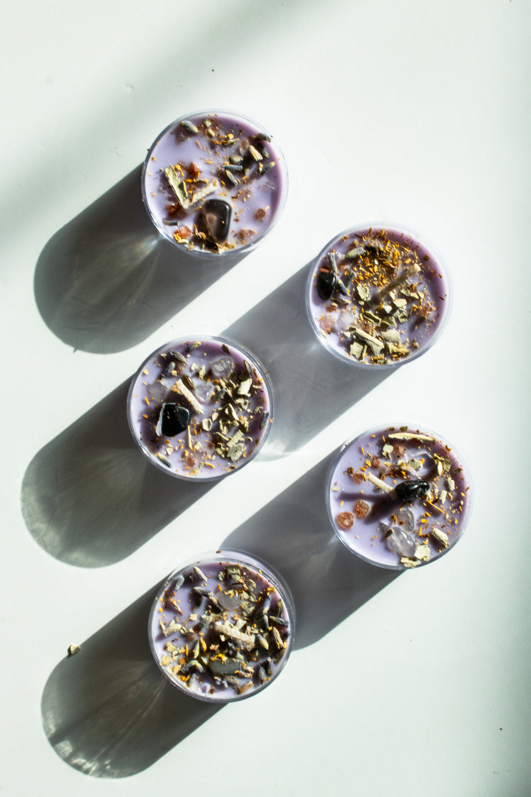 purple tea light candles topped with crystals and white sage for protection